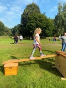 Ein Mädchen balanciert über ein Holzbrett
